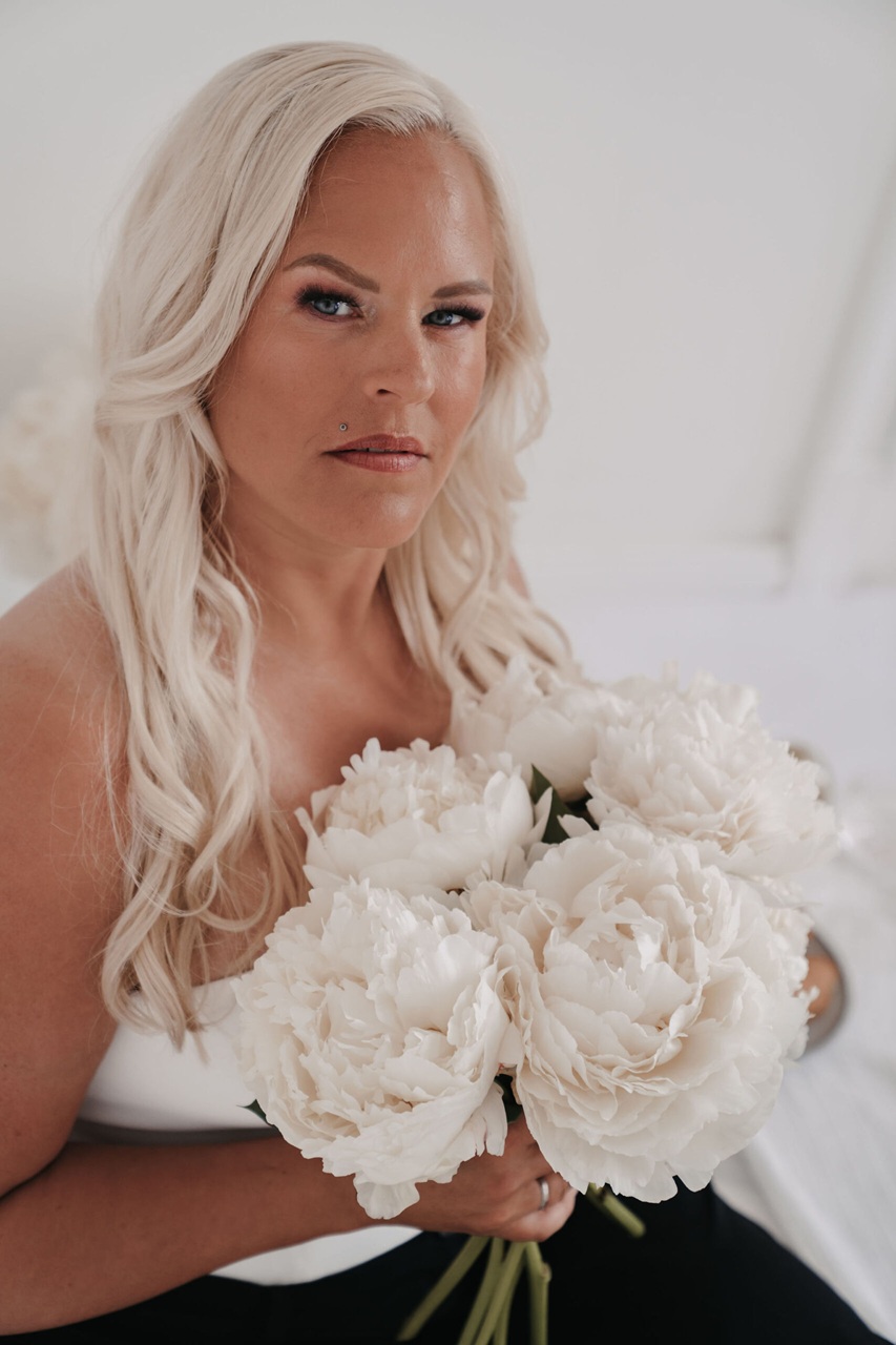 Porträt einer Hochzeitsplanerin mit weißen Pfingstrosen – persönliches Bild auf der Über-mich-Seite.