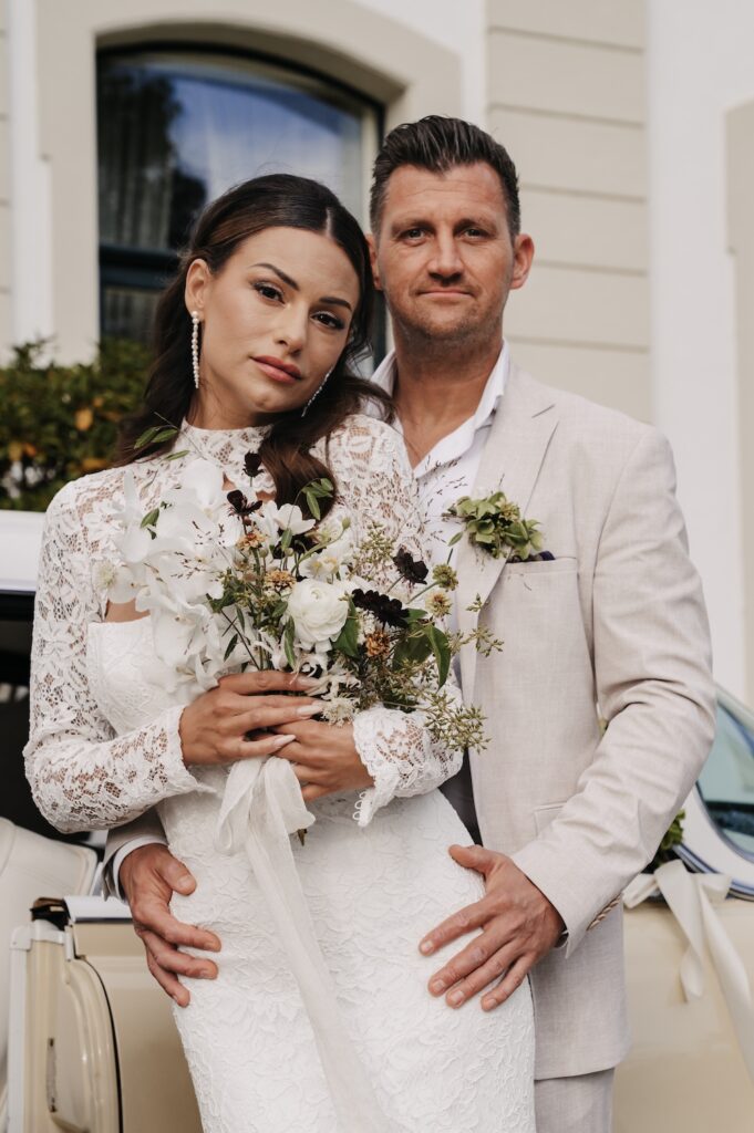 Elegantes Hochzeitspaar posiert vor einer stilvollen Location – modernes und hochwertiges Hochzeitsfoto.