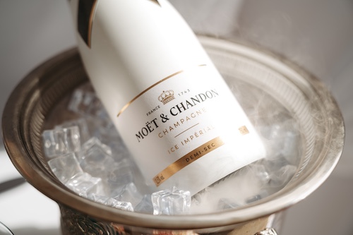 Detailaufnahme einer Moët & Chandon Champagnerflasche im Eiskühler – Symbol für transparente Premium-Leistungen zum Festpreis.