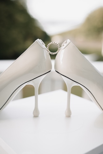 Detailaufnahme eleganter Brautschuhe mit Verlobungsring – stilvolles Hochzeitsdetail.